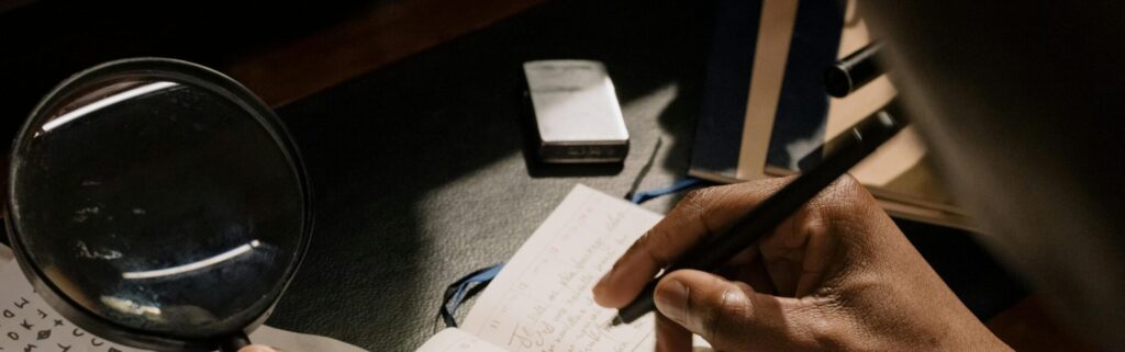 A detective decoding cipher documents with a magnifying glass, notebook in hand.